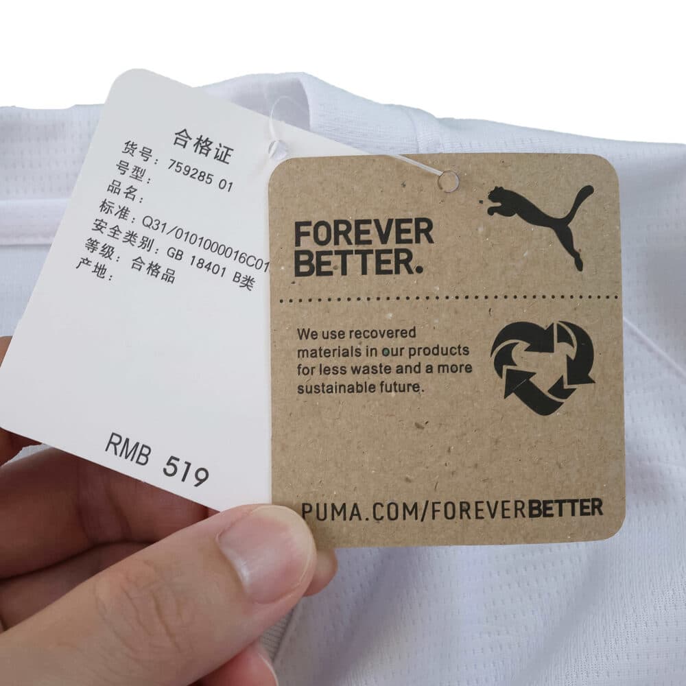 Close-up of Valencia Home 2025/26 Fan Version tags, showing pricing and Puma "Forever Better" sustainability label.