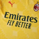 Close-up of AC Milan Third 2025/26 Player Version jersey, yellow with club badge and sponsor logos.