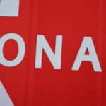 Close-up of red AS Monaco 2025/26 Home Fan jersey showing part of white text "ONA" on fabric.
