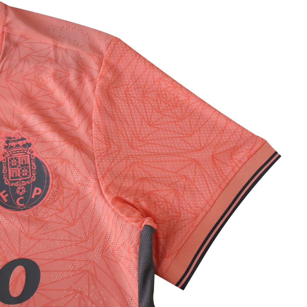 Close-up of the FC Porto Away 2025/26 Player Version jersey sleeve in coral with black trim and club badge.