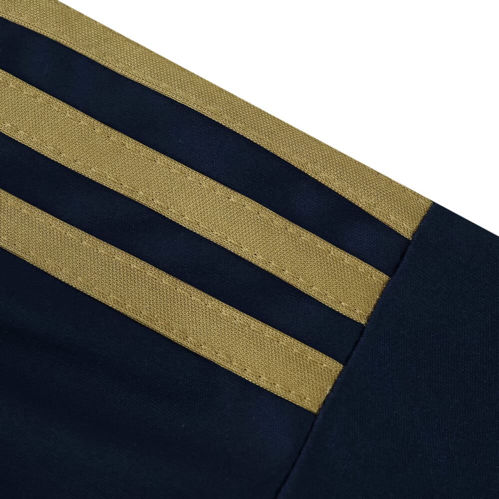 Close-up of the Fenerbahce 2025/26 Third fan jersey sleeve with gold stripes on navy fabric.
