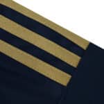 Close-up of the Fenerbahce 2025/26 Third fan jersey sleeve with gold stripes on navy fabric.