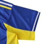 Close-up of Leeds United 2025/26 away fan jersey sleeve in blue and yellow with white stripes
