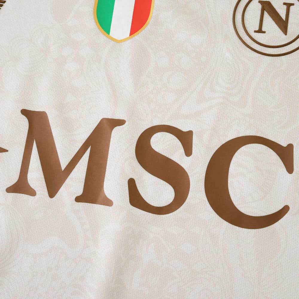 Close-up of Napoli Away 2025/26 Fan Version jersey featuring sponsor logo and team crest on white fabric.