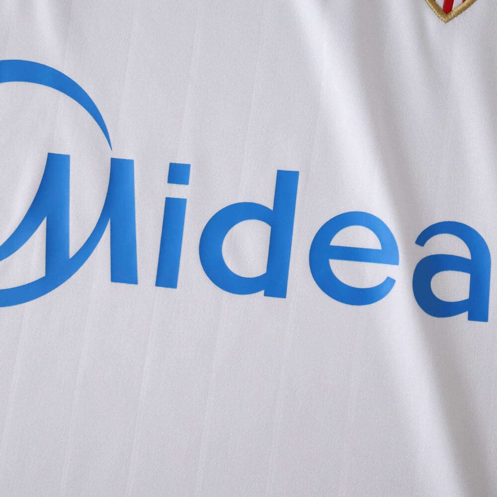 Close-up of Sevilla FC 2025/26 home fan jersey showing sponsor logo "Midea" on white fabric.