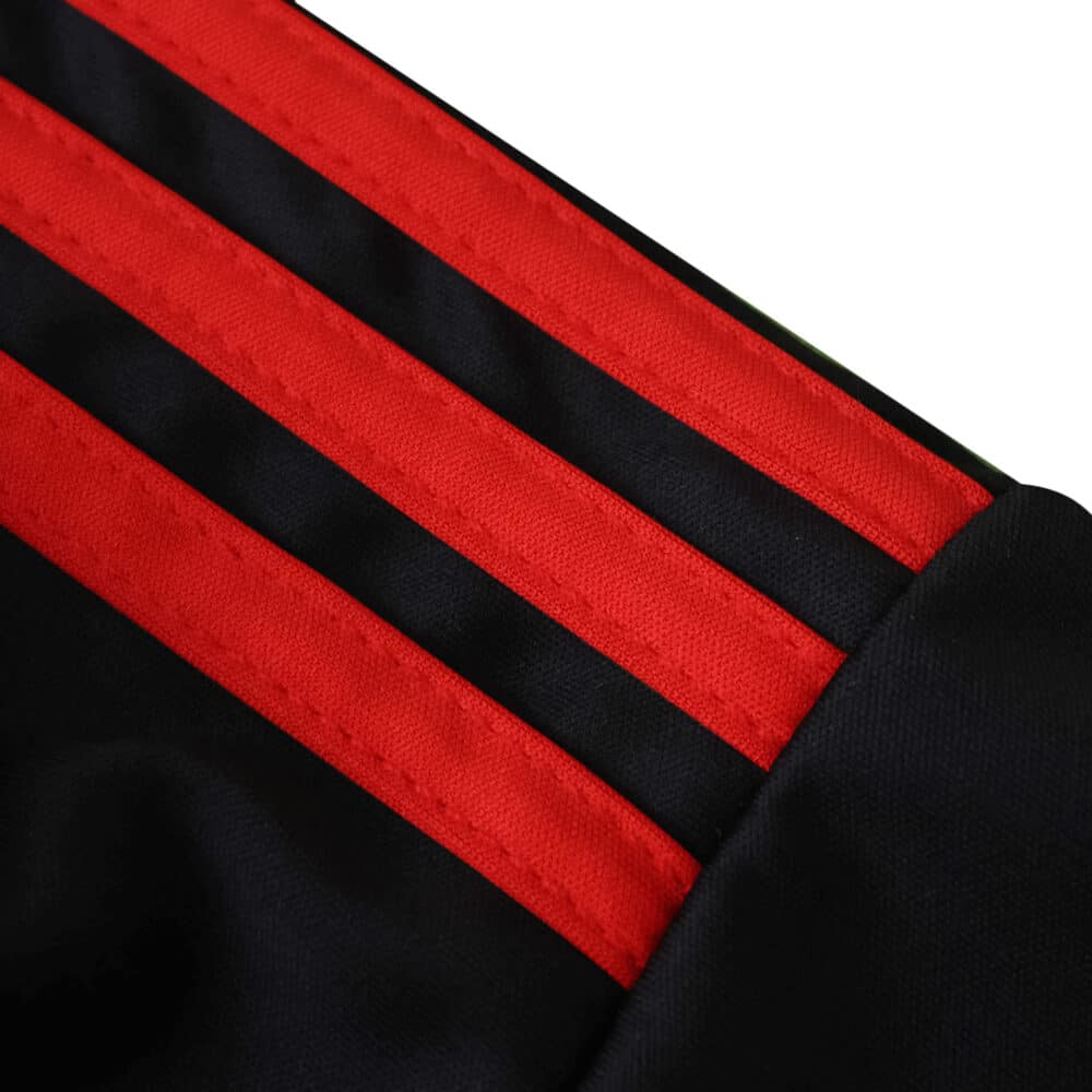 Close-up of Sevilla FC 2025/26 Third Fan jersey showing black fabric with three bold red stripes on the shoulder.
