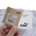 Close-up of Puma product tags attached to the Valencia Home 2025/26 Fan Version jersey.